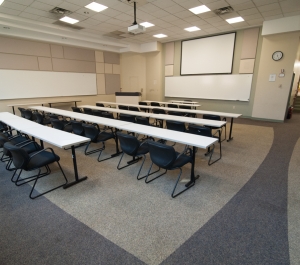 Classroom 115, rows of chairs facing projection screen