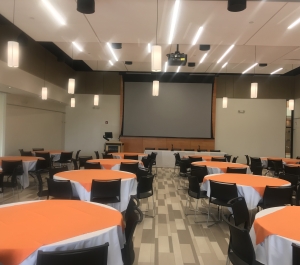 Costello Hall, round tables with chairs and projection screen